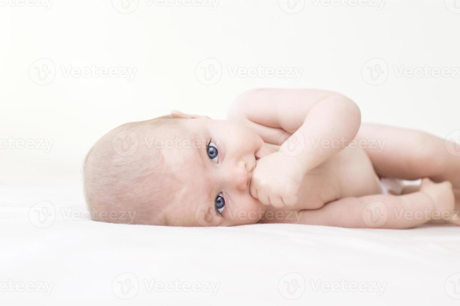 Cute baby girl lying on bed photo