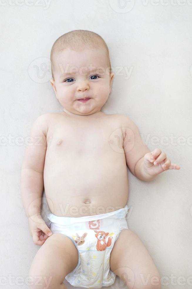 Cute baby girl lying on bed photo