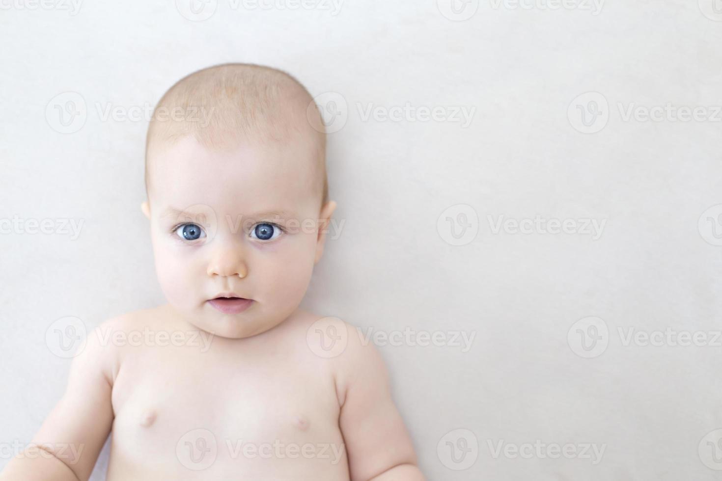 Cute baby girl lying on bed photo