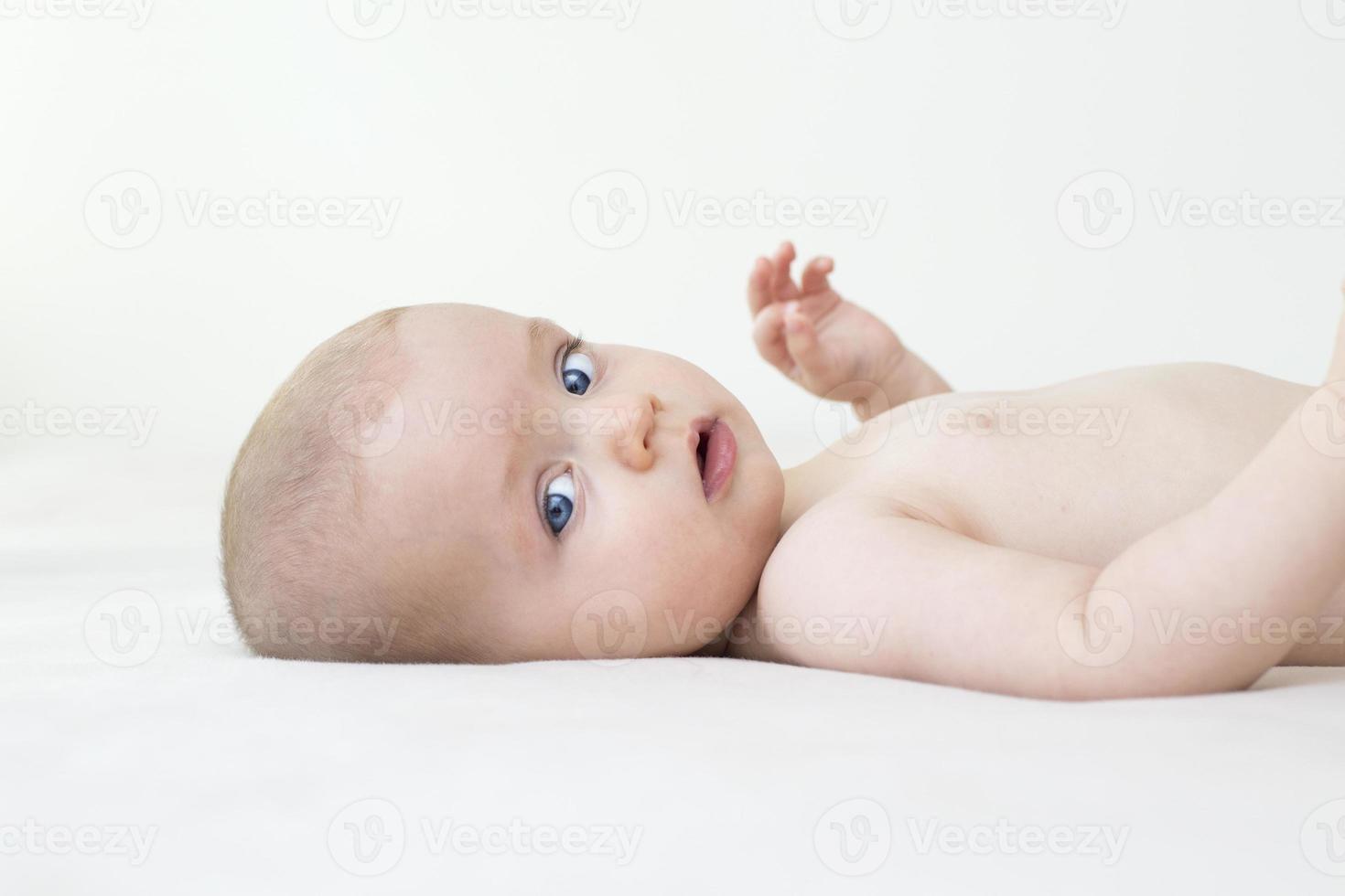 Cute baby girl lying on bed photo