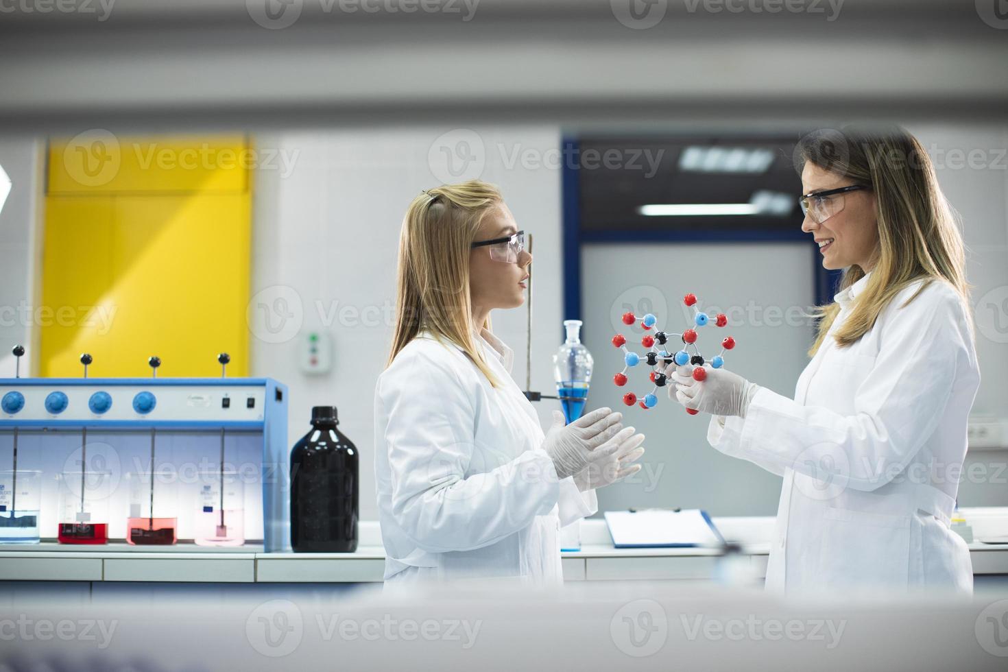 mujeres químicas tienen un modelo molecular en el laboratorio. foto