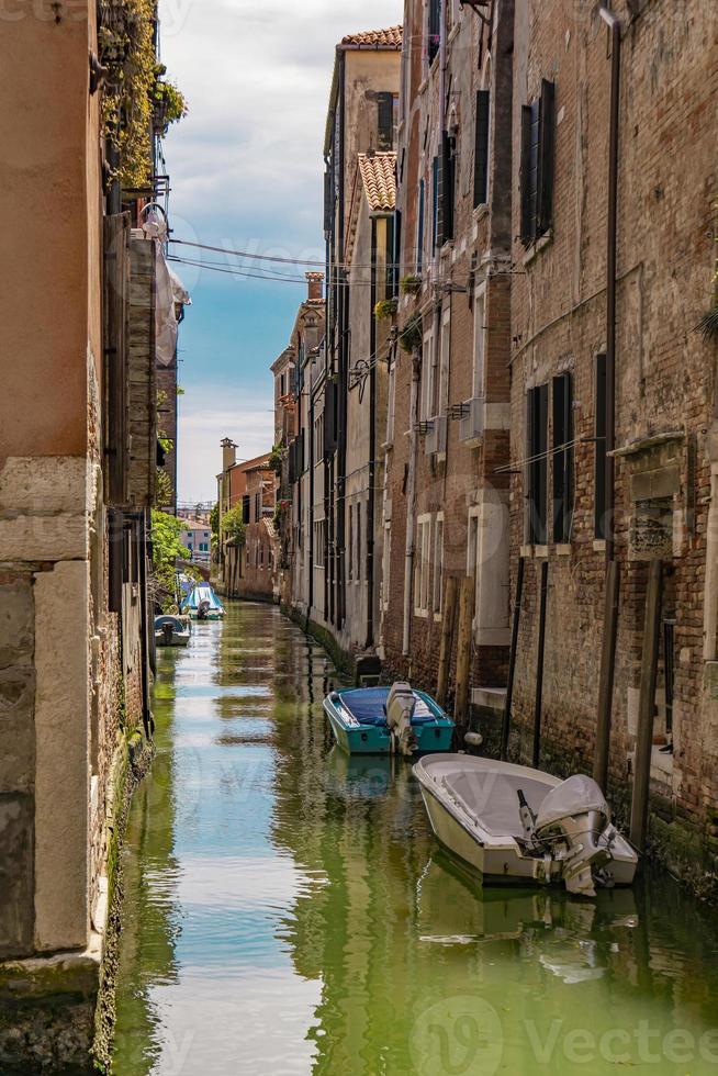 Street canal with boats in Venice, Italy photo