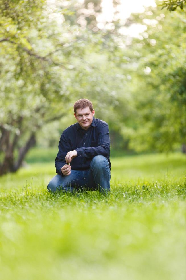 Man kneeling in a park photo