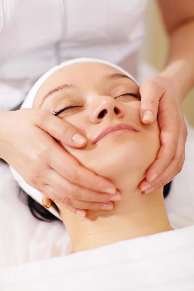 mujer en el spa de belleza recibiendo un masaje facial foto