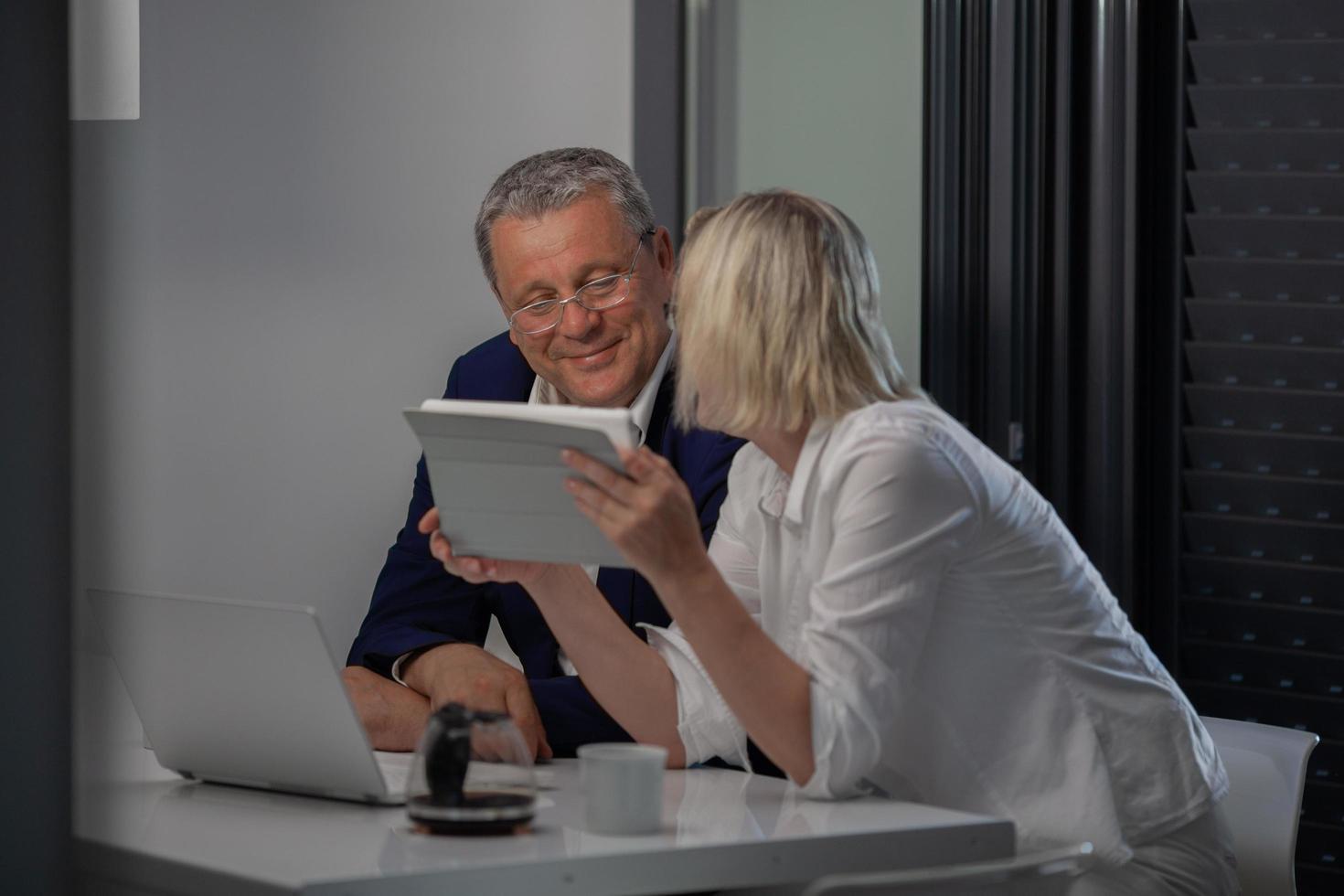 una pareja de mediana edad en la mesa con una tableta foto