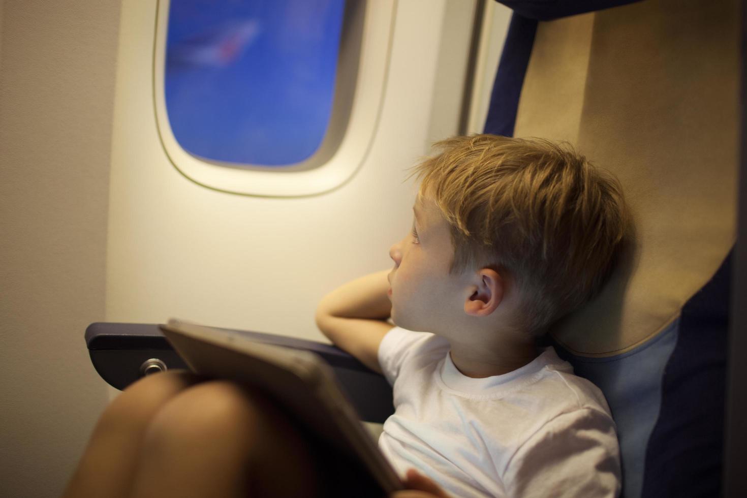 Boy in plane looking out window photo