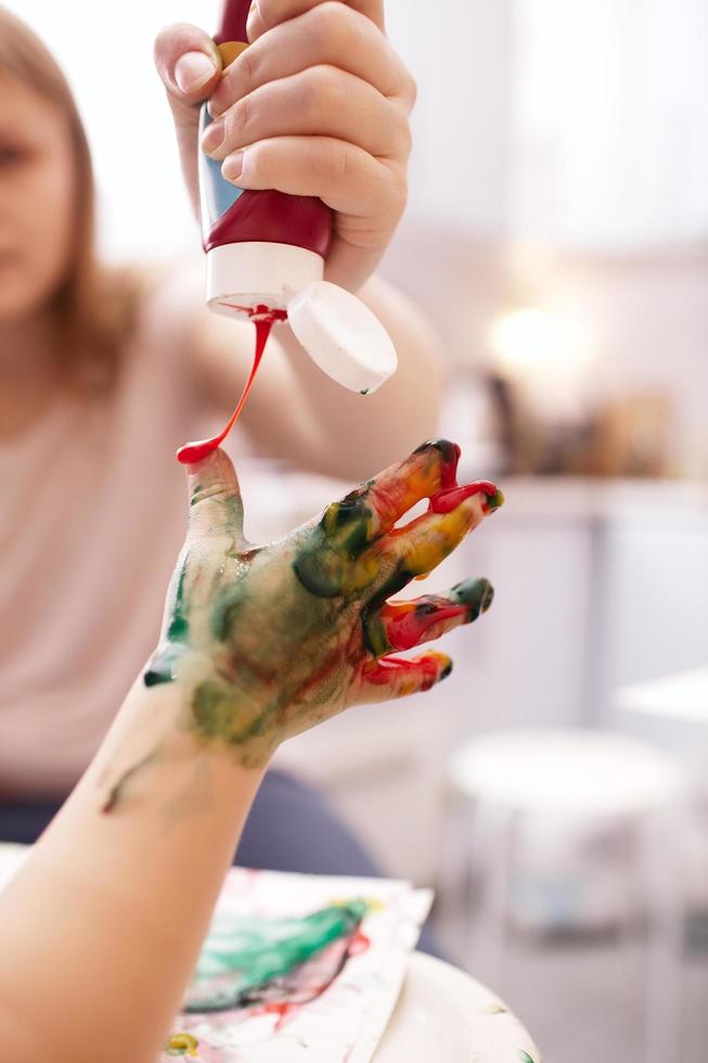 Paint being applied to a child's hand photo