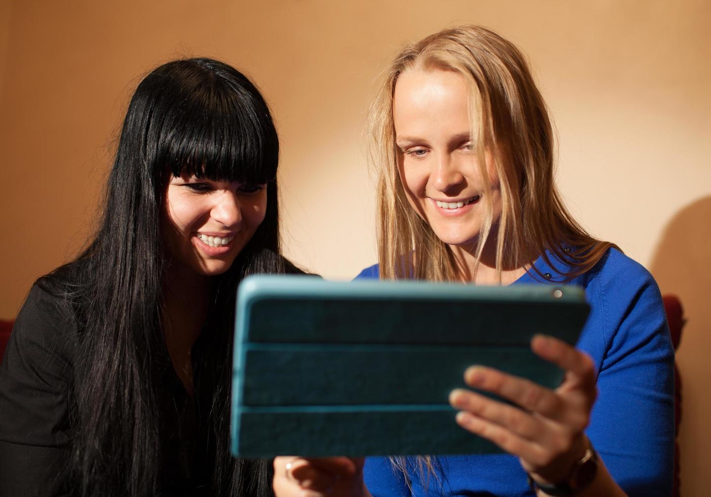 Two young women using a tablet photo