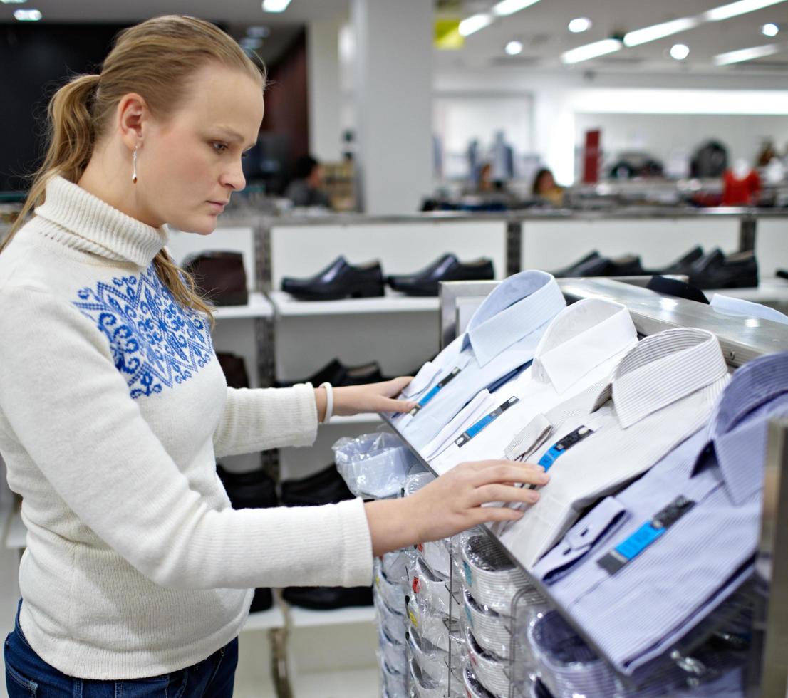 Woman is choosing a men's shirt photo