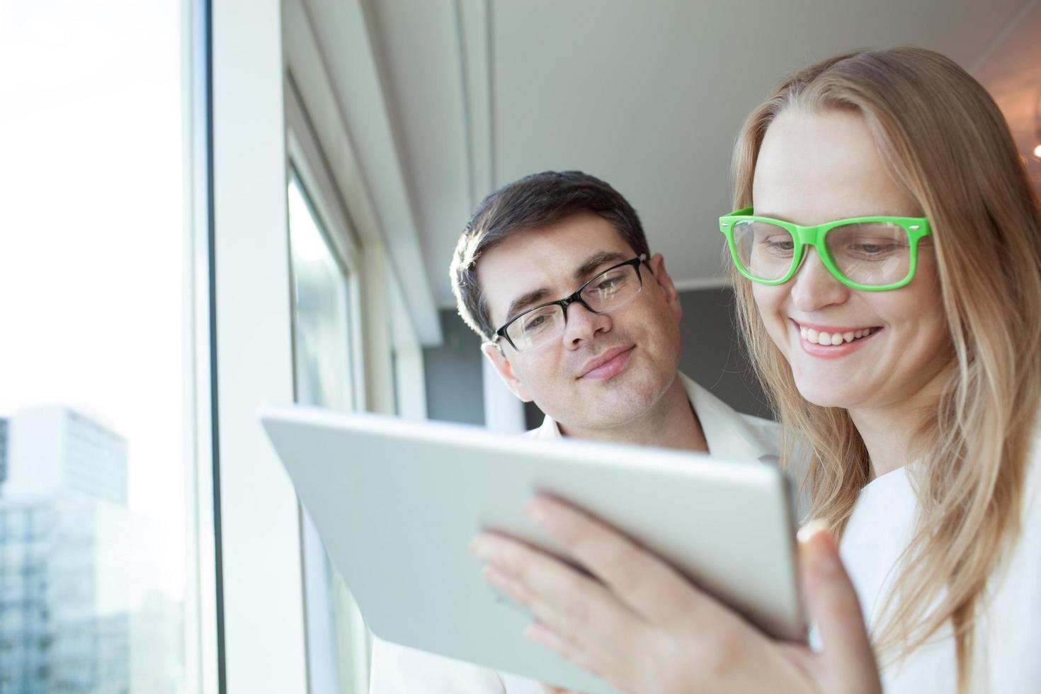 pareja con gafas usando una tableta foto