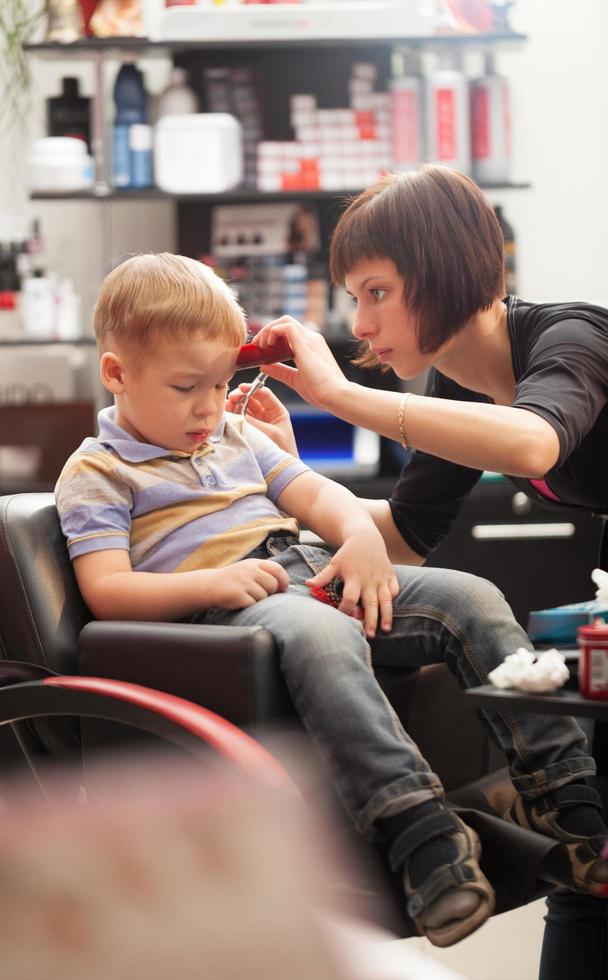 Boy getting a haircut in a salon photo