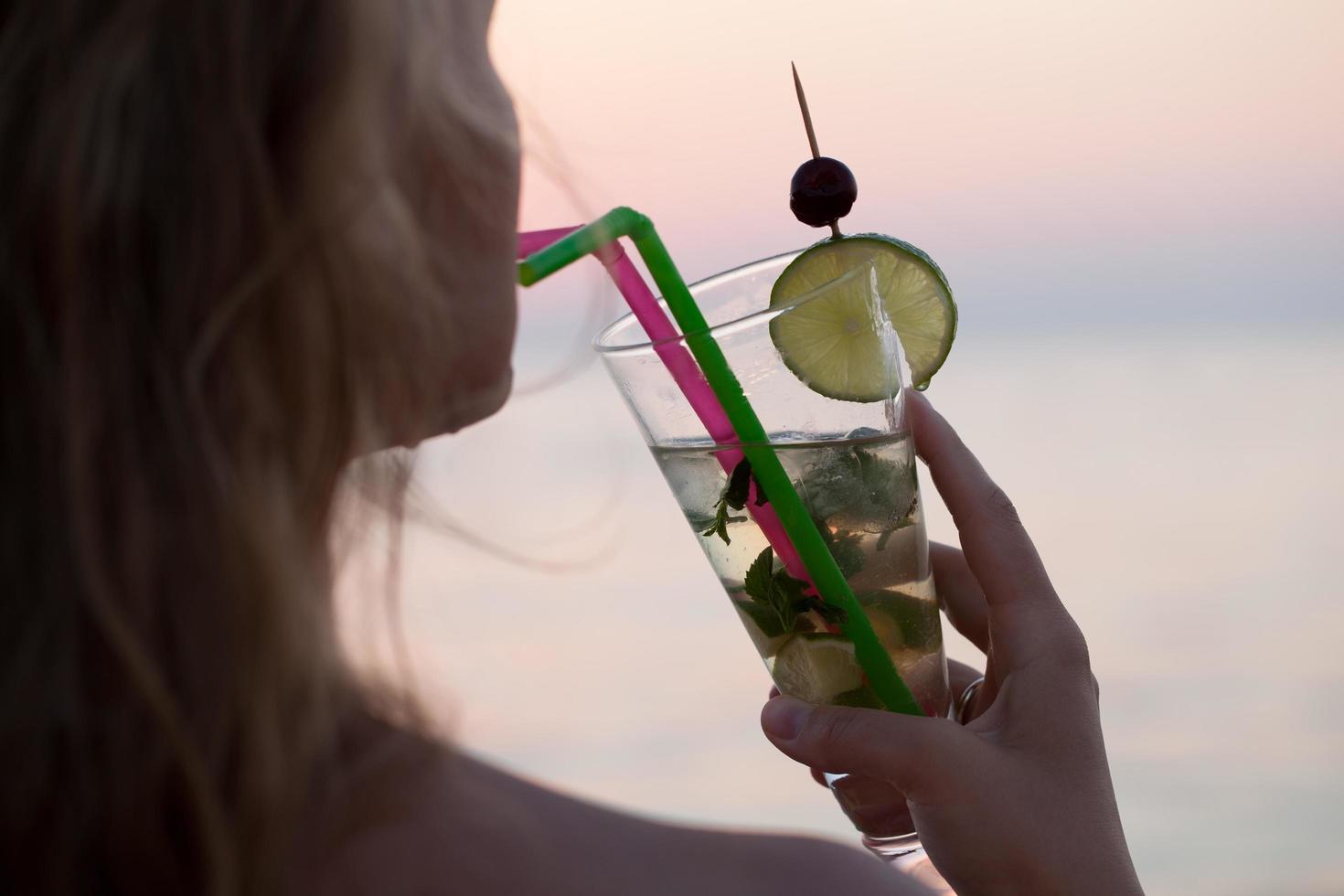 Woman drinking a mojito cocktail photo