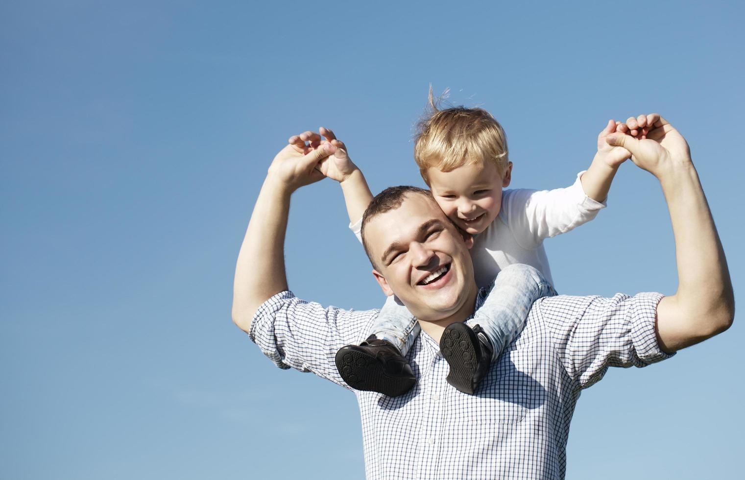 Dad giving his young son a piggyback ride photo