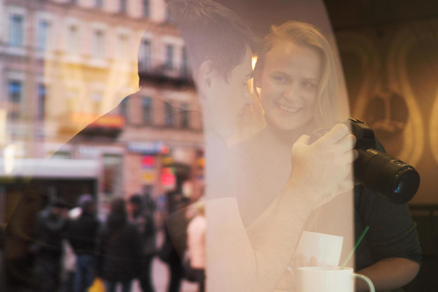 pareja con cámara detrás de un vidrio foto