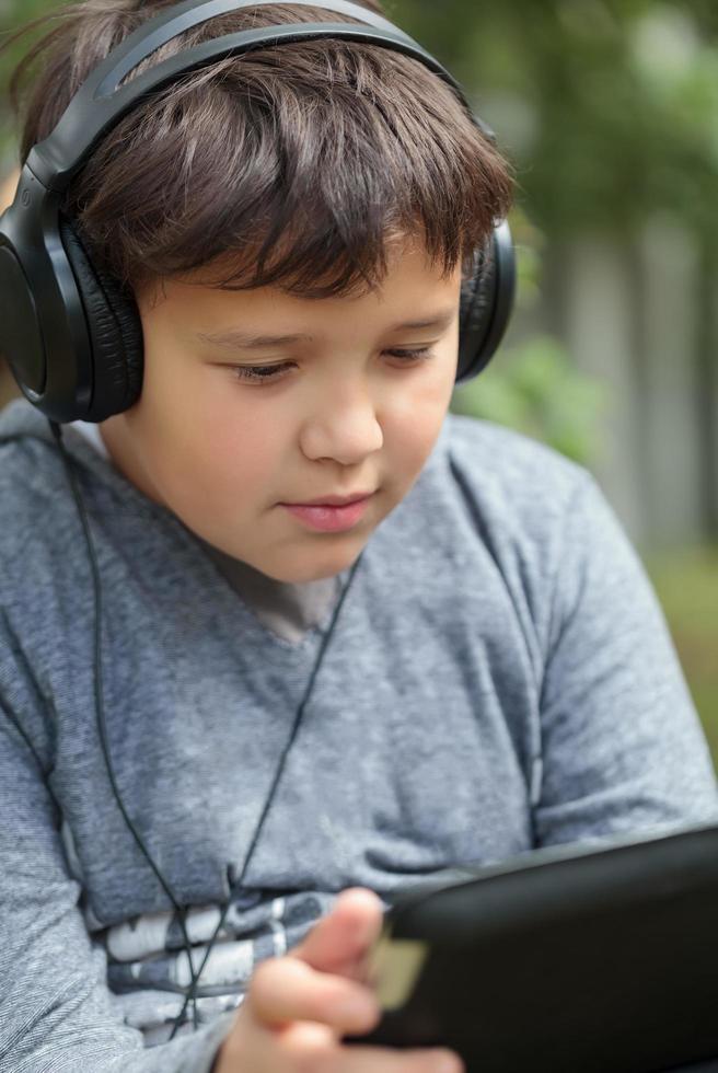 Teenager in headphones using a tablet photo