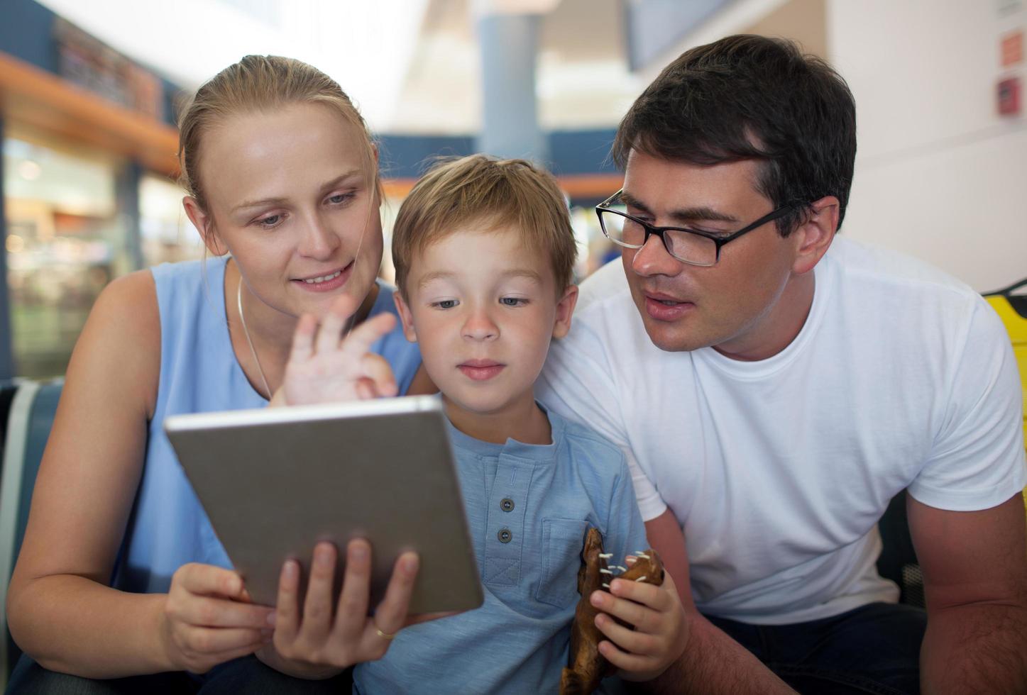 Parents and son with tablet at the airport photo