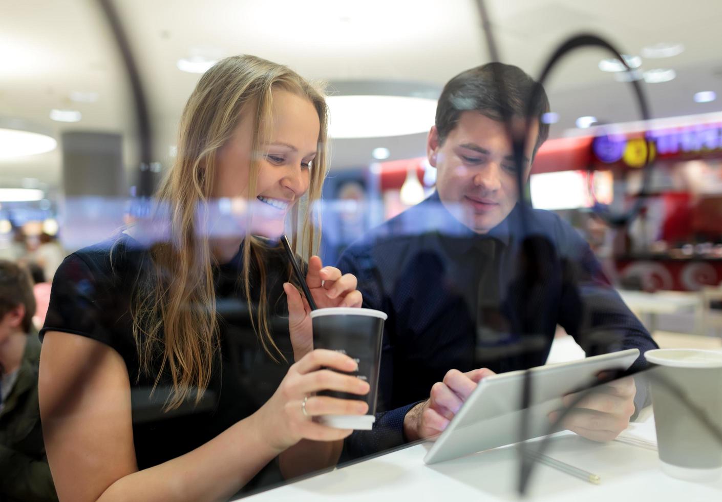 hombre y mujer usando una tableta en un café foto