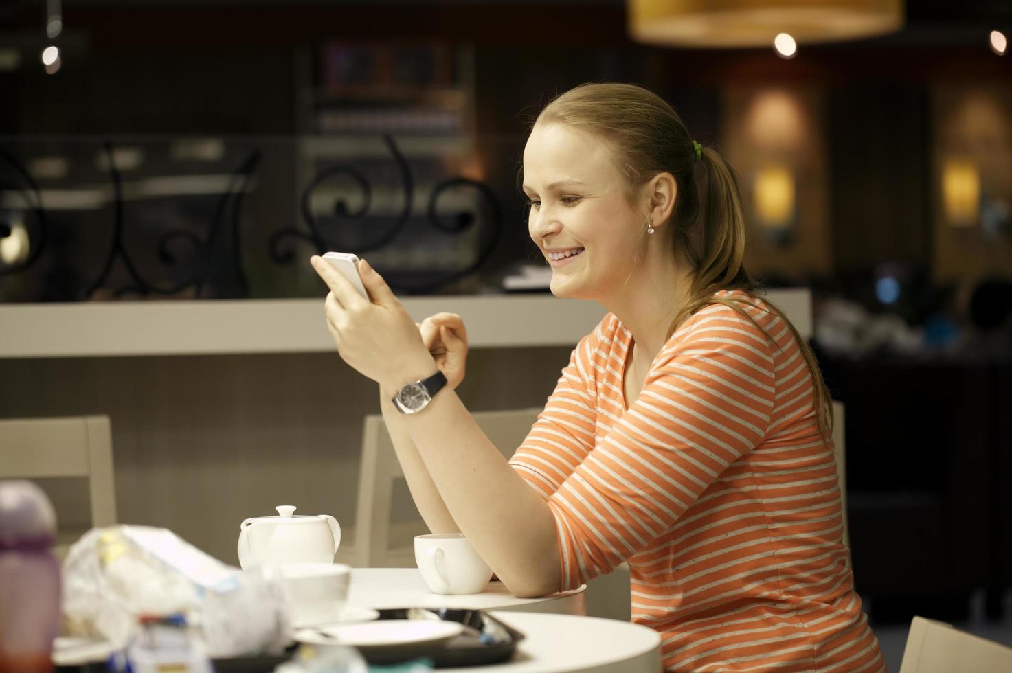 mujer en su teléfono en un restaurante foto