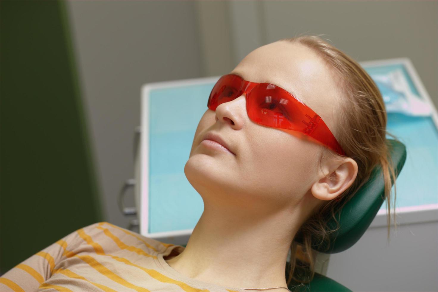 Woman in red safety glasses in a dental office photo