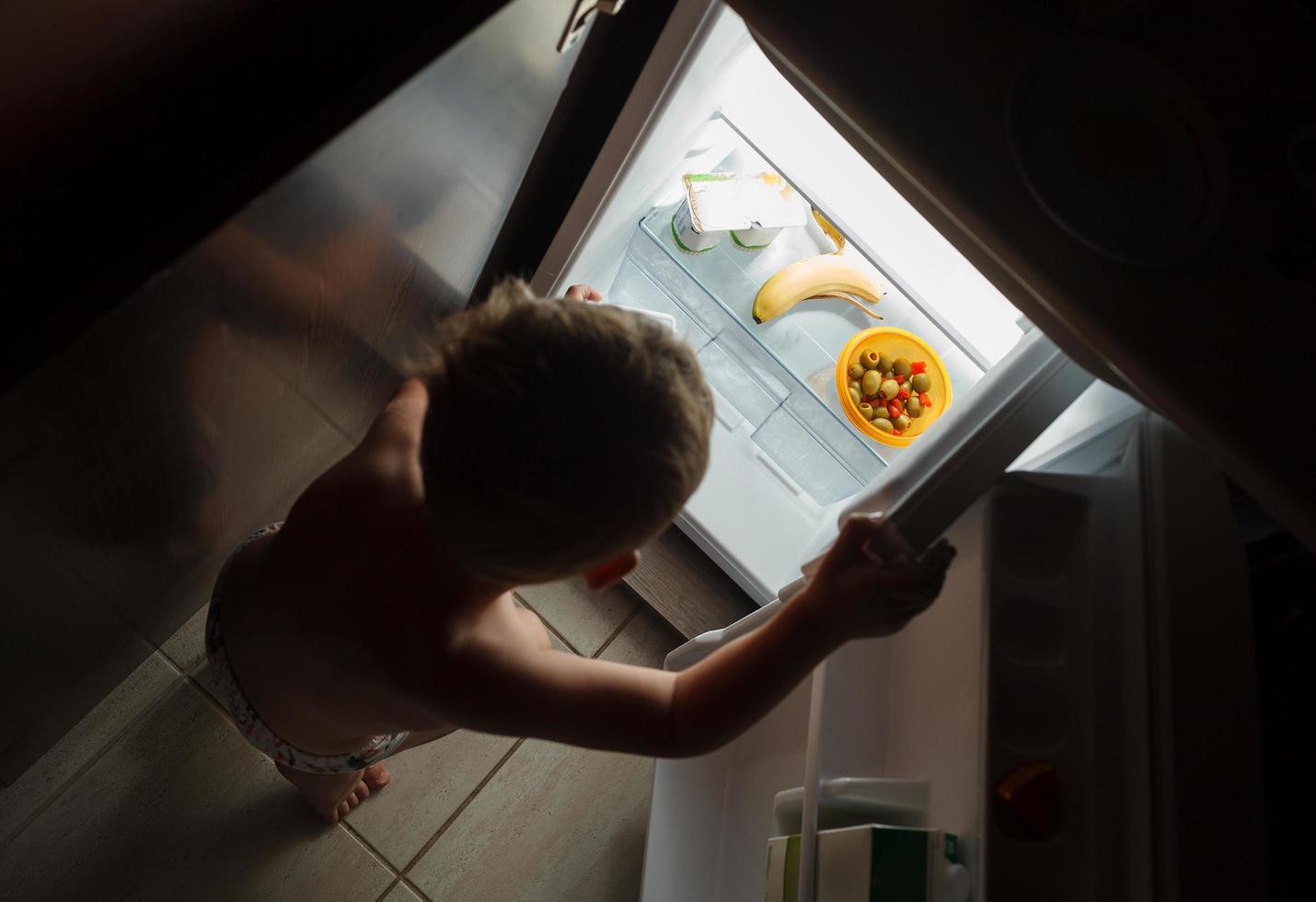 niño comiendo un bocadillo tarde en la noche foto