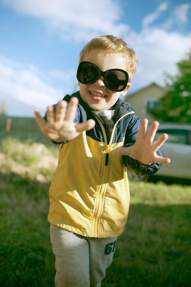 niño feliz en grandes gafas de sol afuera foto