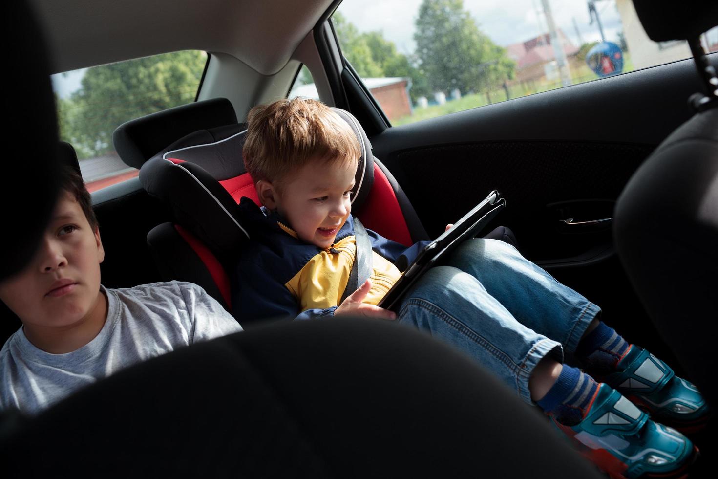 dos niños en el asiento trasero de un auto foto