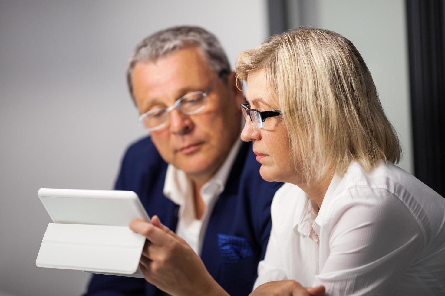 Mature businesspeople working with a tablet photo