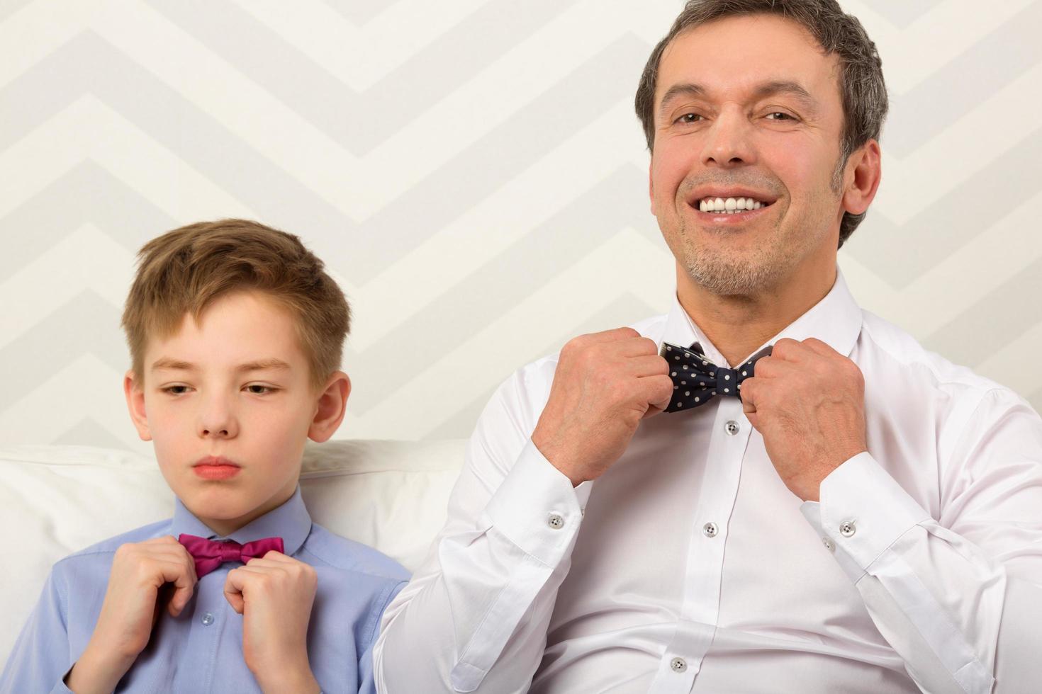 Father and son adjusting bowties photo