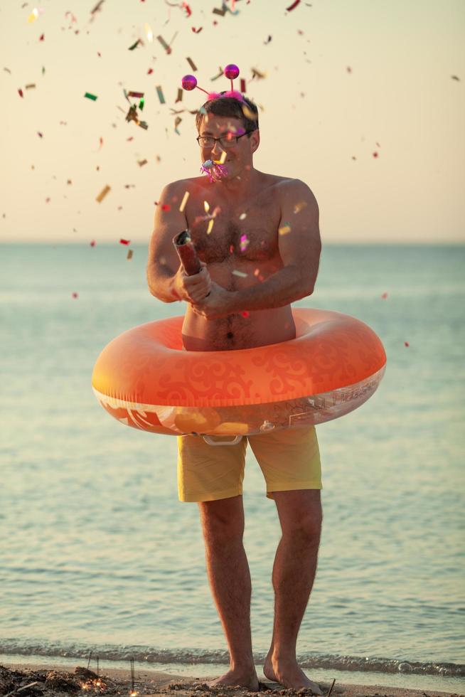 Man throwing confetti on a beach photo