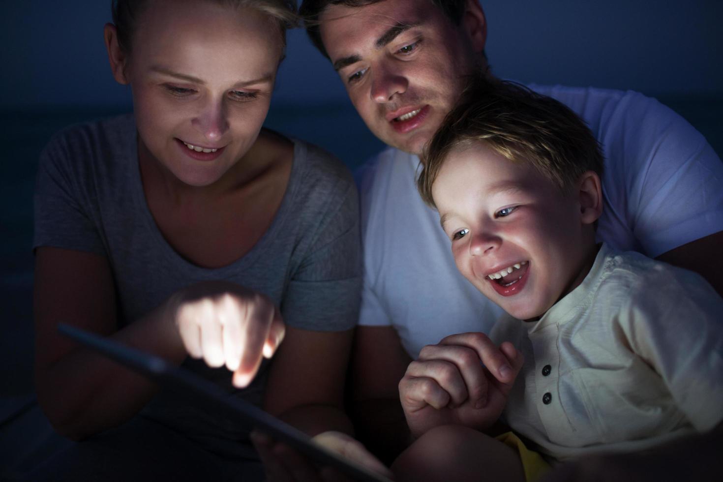 familia usando una tableta por la noche foto
