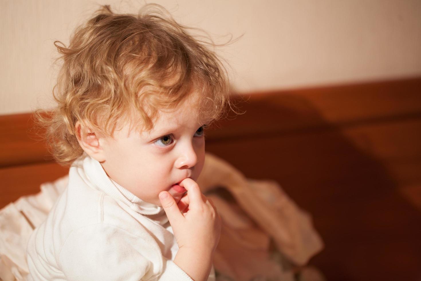 niño mirando hacia adelante con expresión pensativa foto