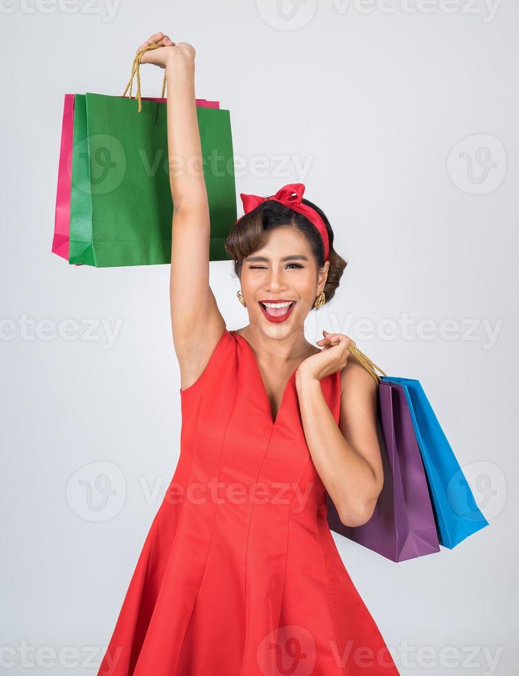 Beautiful Asian woman holding colored shopping bags photo