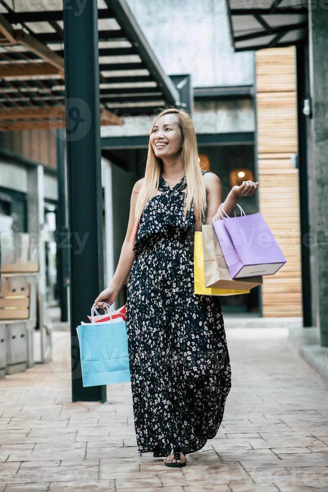 Portrait of a young happy woman with shopping bags walking in the street photo