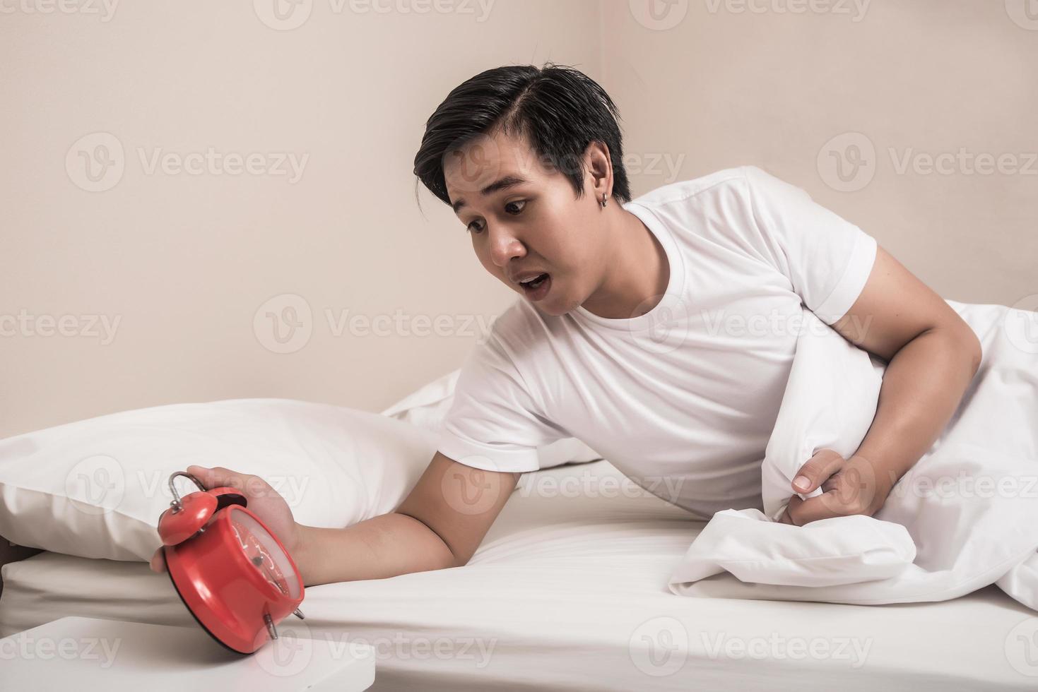 Man turns off alarm clock in a hurry photo