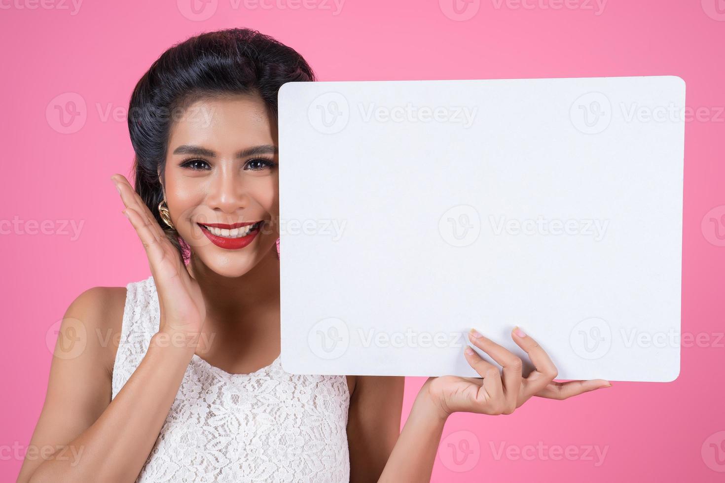 Portrait of a fashionable woman displaying a white banner photo