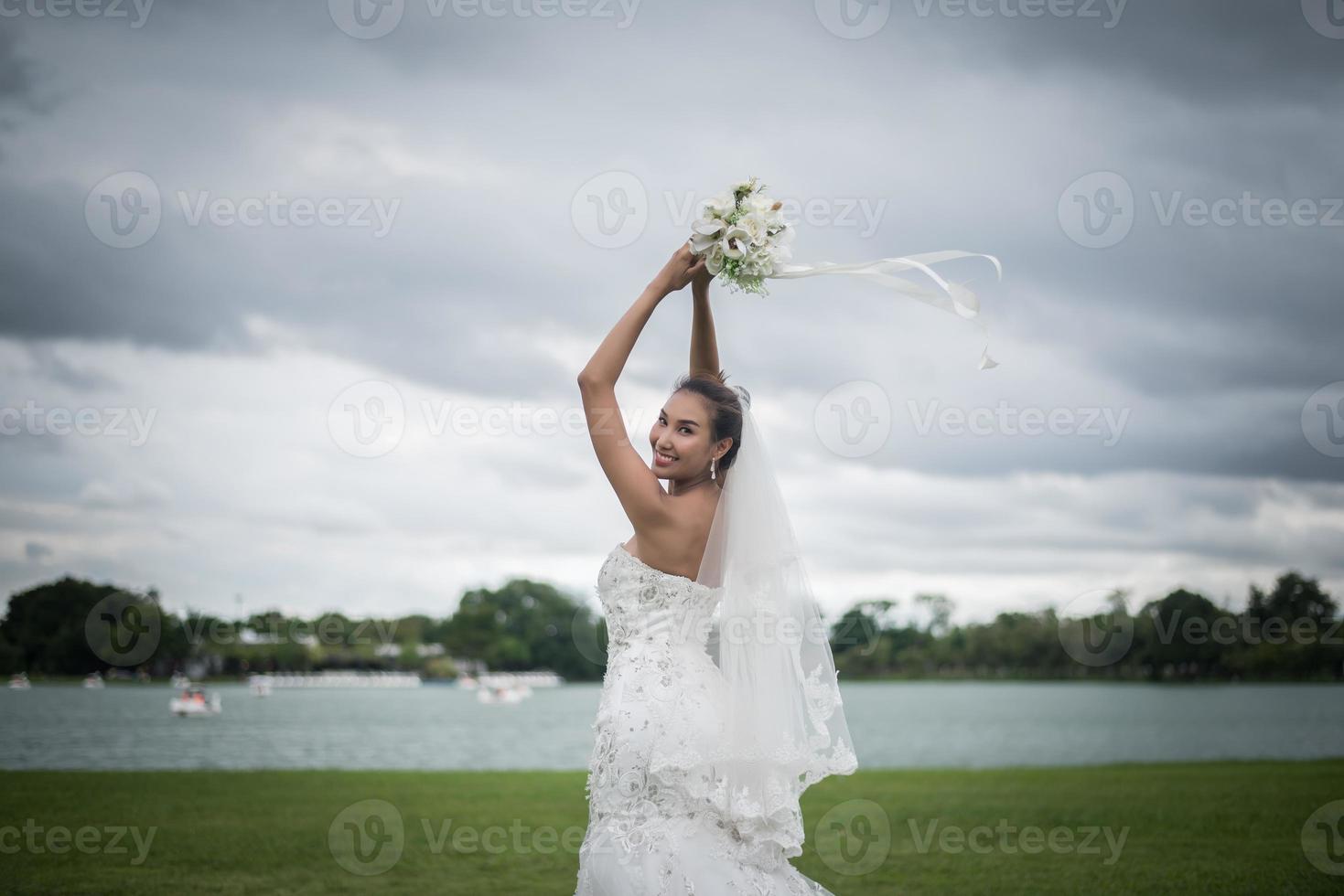 hermosa novia con flores, maquillaje de boda y peinado foto