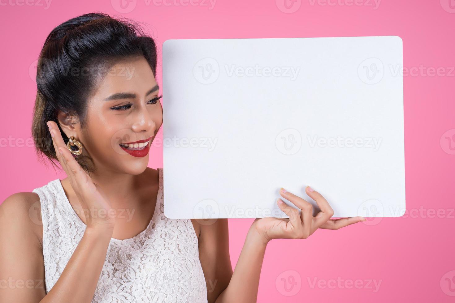 Retrato de una mujer de moda mostrando una pancarta blanca foto