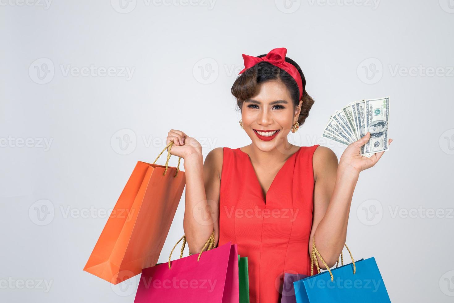 Beautiful Asian woman holding colored shopping bags photo