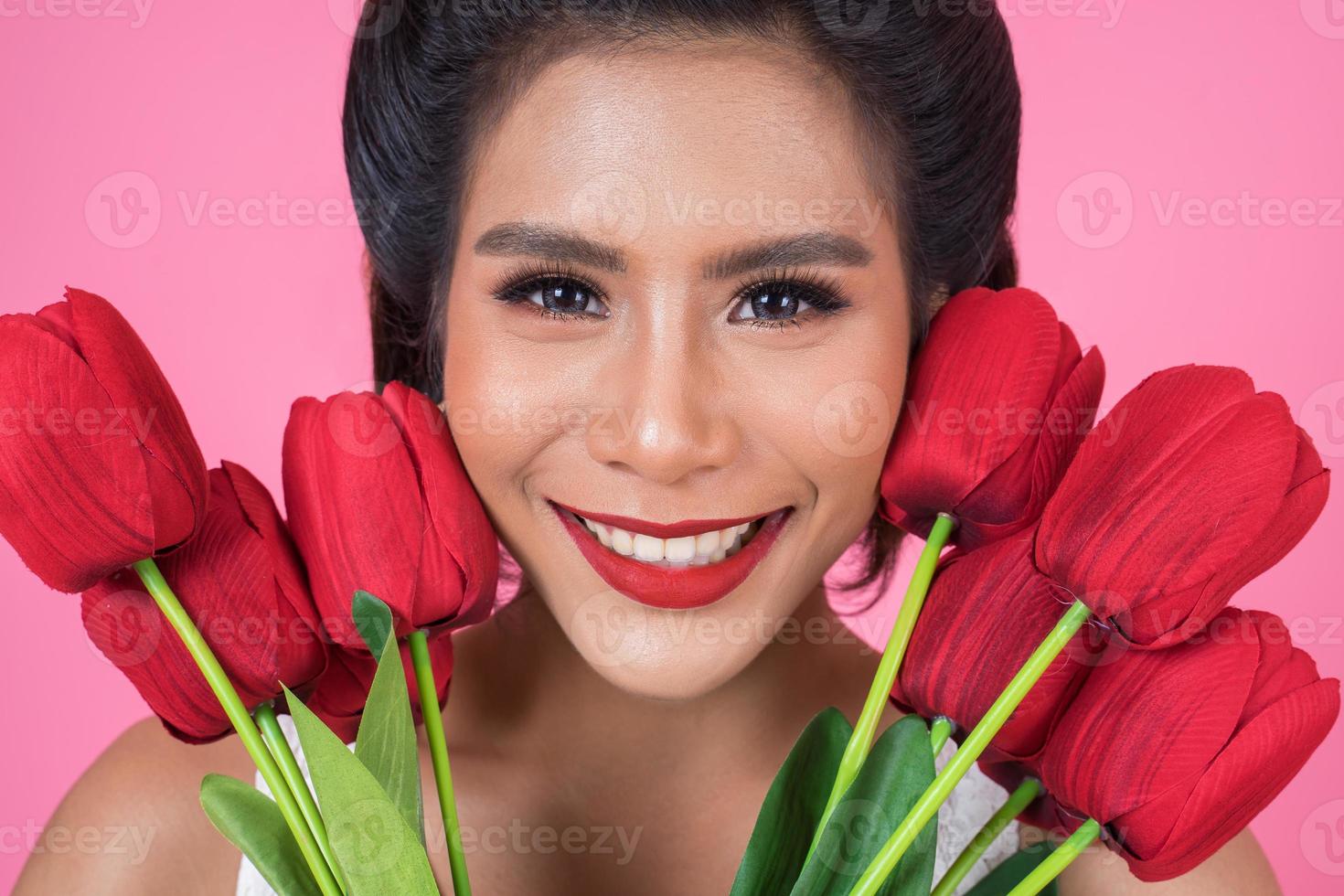 Retrato de una bella mujer con ramo de flores de tulipán rojo foto