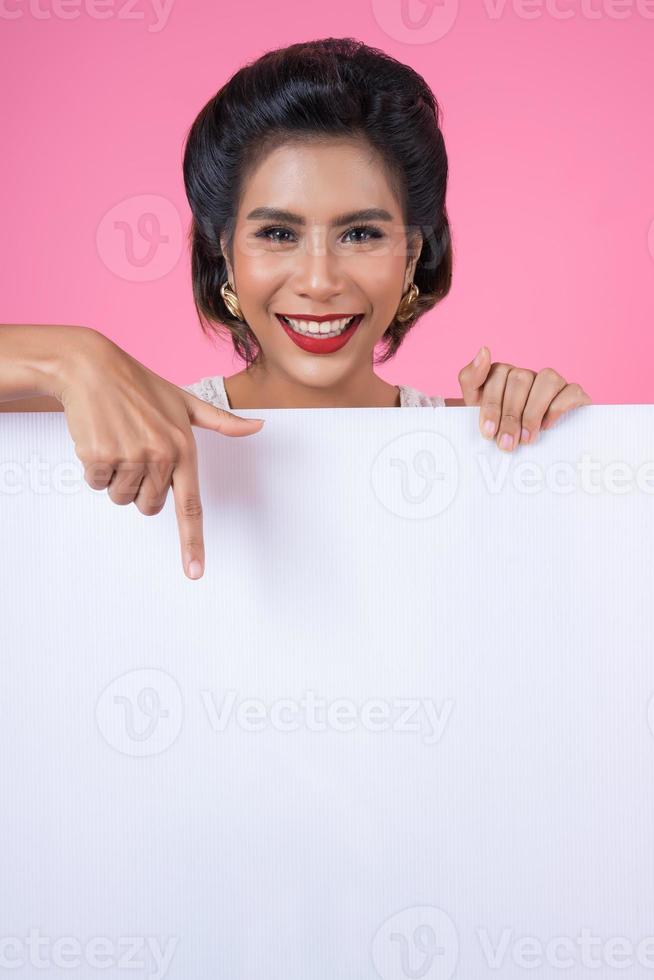 Retrato de una mujer de moda mostrando una pancarta blanca foto