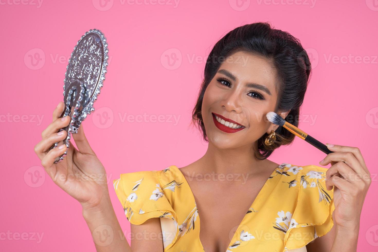 Fashionable woman with makeup and mirror photo