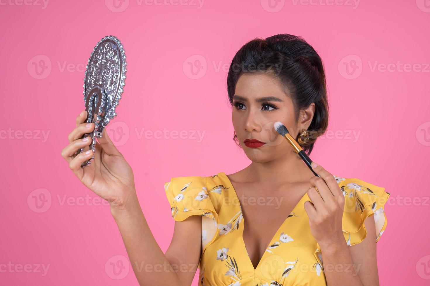 Fashionable woman with makeup and mirror photo