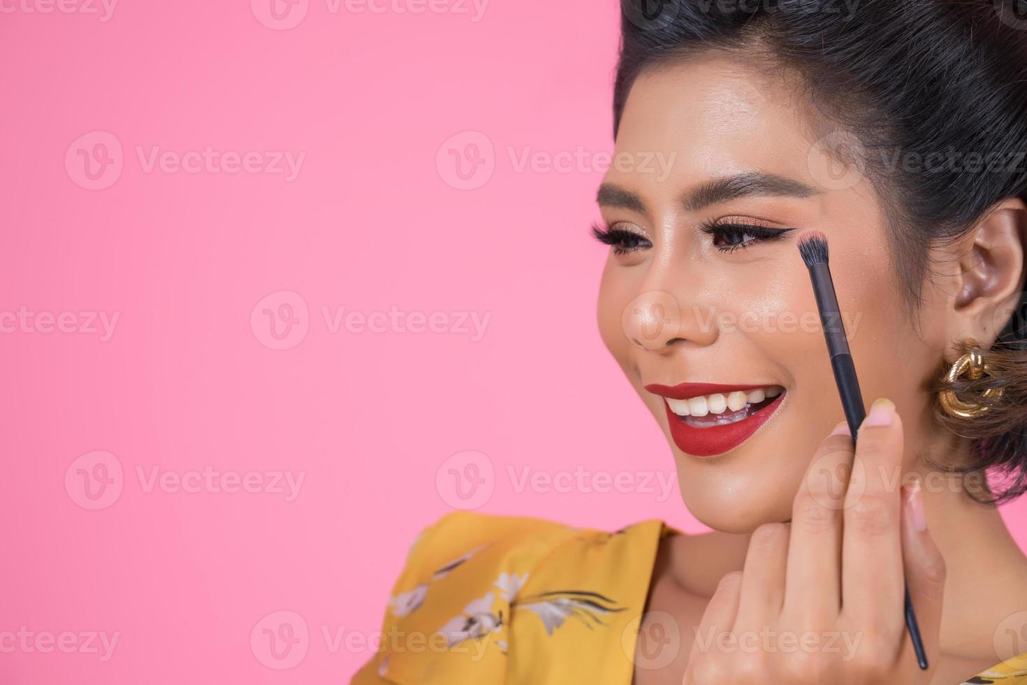 retrato de una mujer con pincel de maquillaje foto