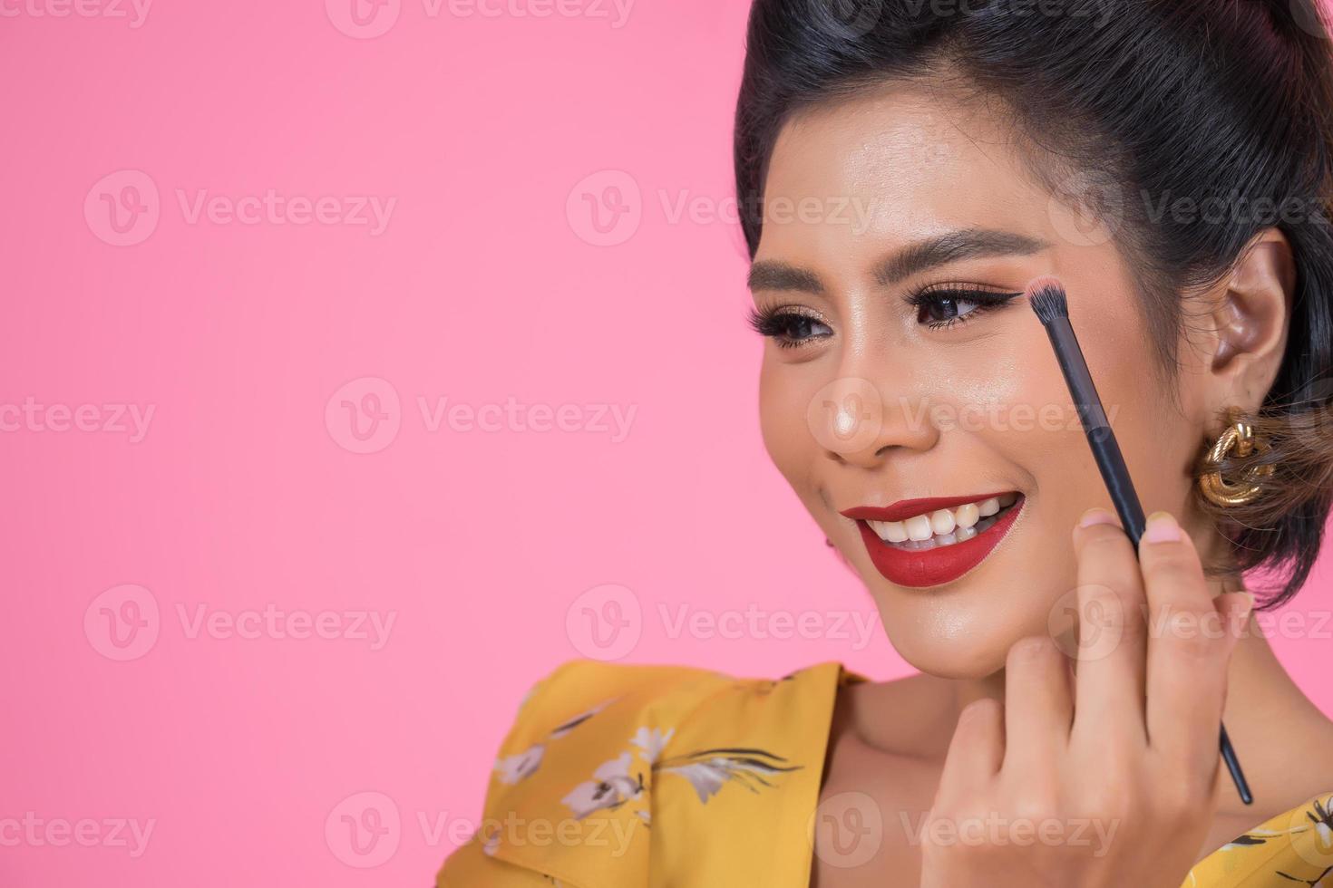 Portrait of a woman with makeup brushes photo