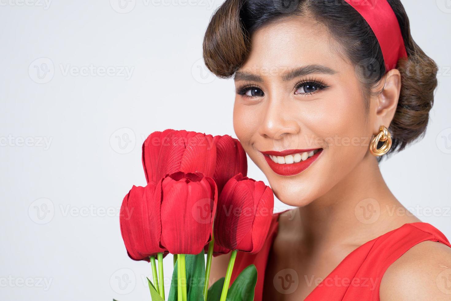 Portrait of a beautiful woman with bouquet of red tulip flowers photo