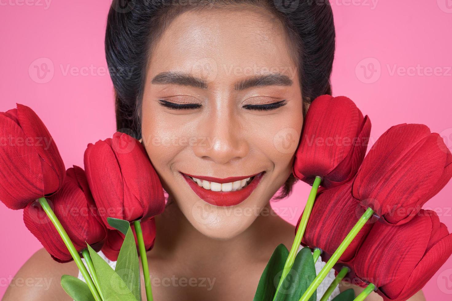 Portrait of a beautiful woman with bouquet of red tulip flowers photo