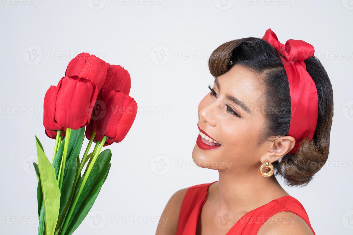 Portrait of a beautiful woman with bouquet of red tulip flowers photo