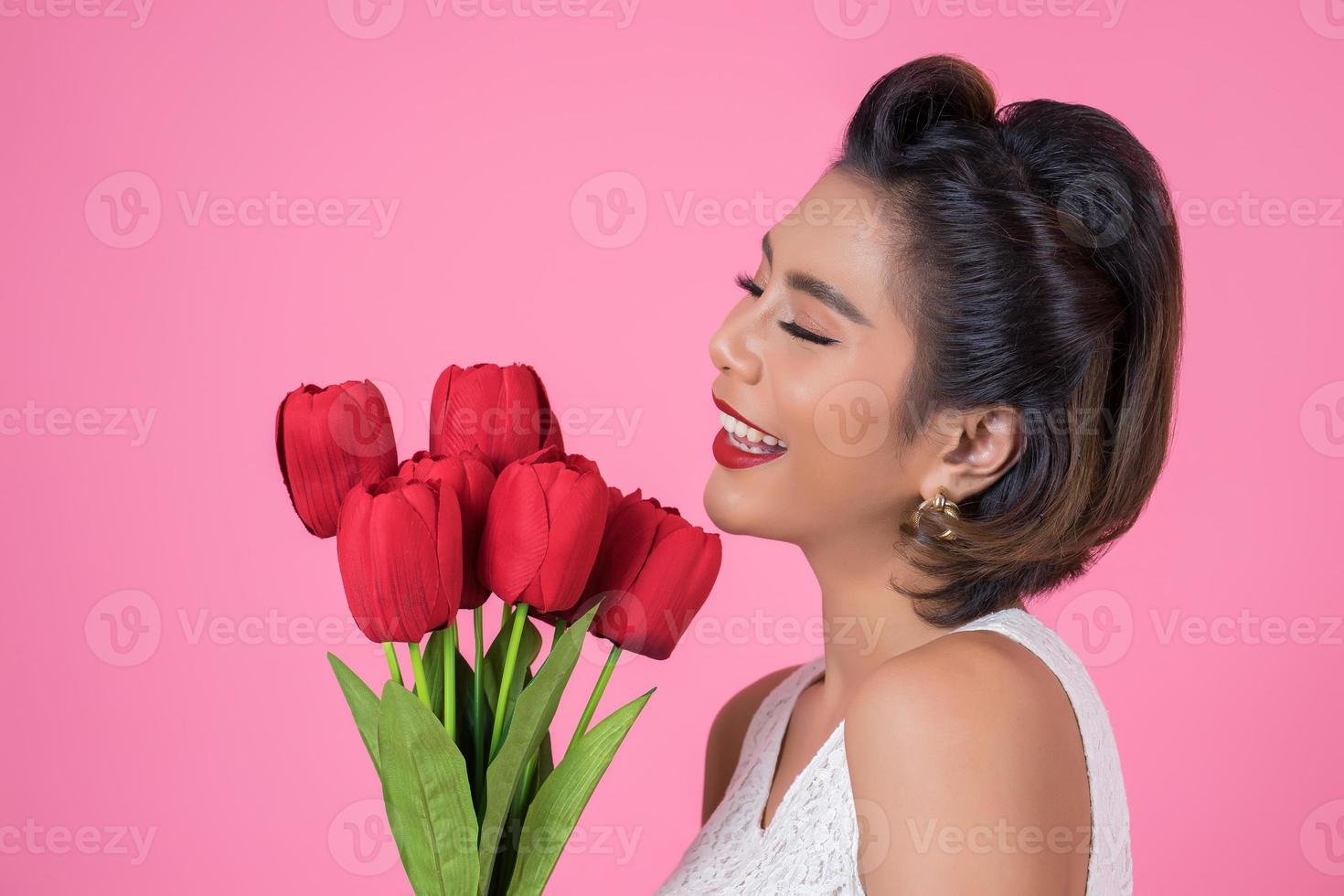 Portrait of a beautiful woman with bouquet of red tulip flowers photo