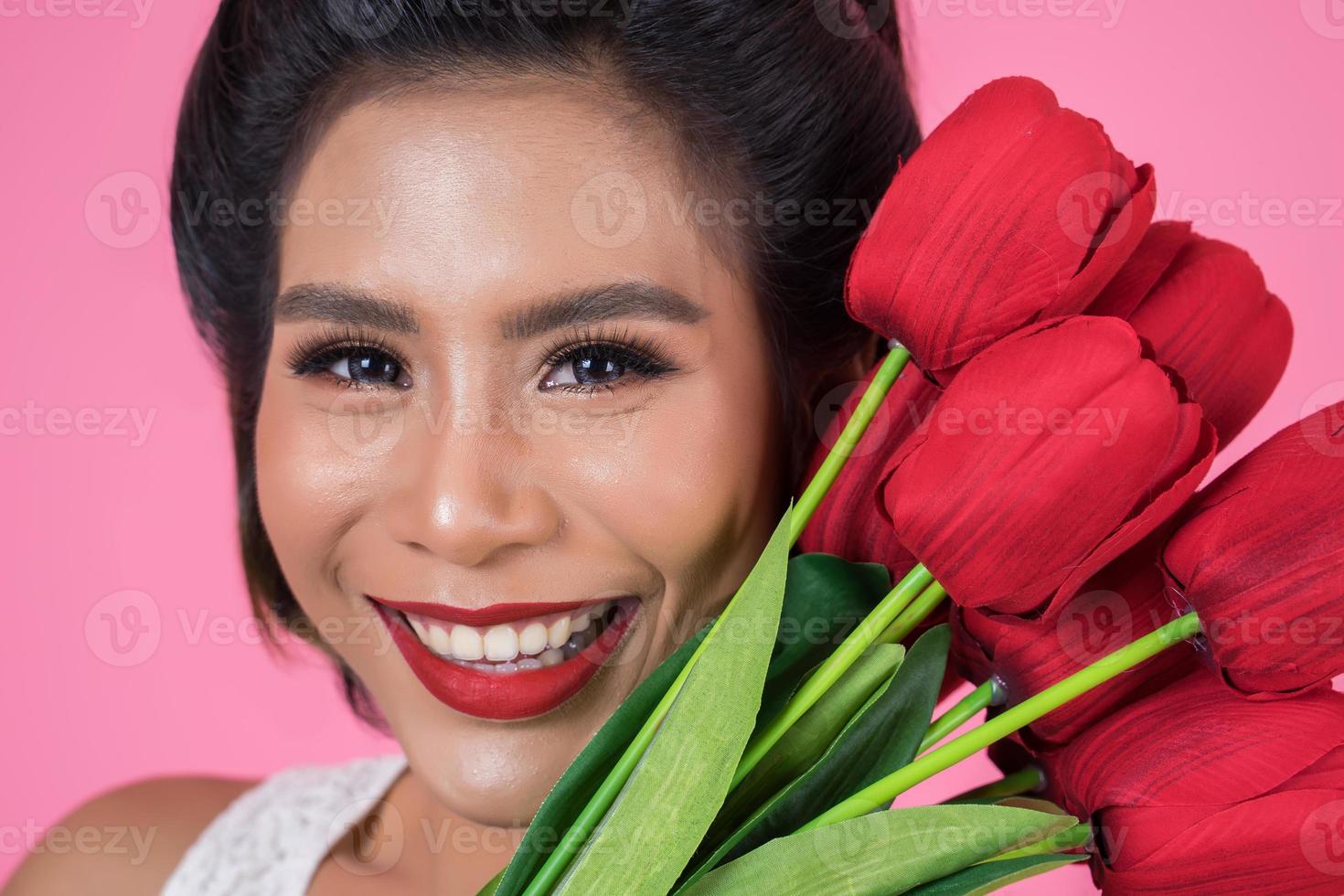 Portrait of a beautiful woman with bouquet of red tulip flowers photo