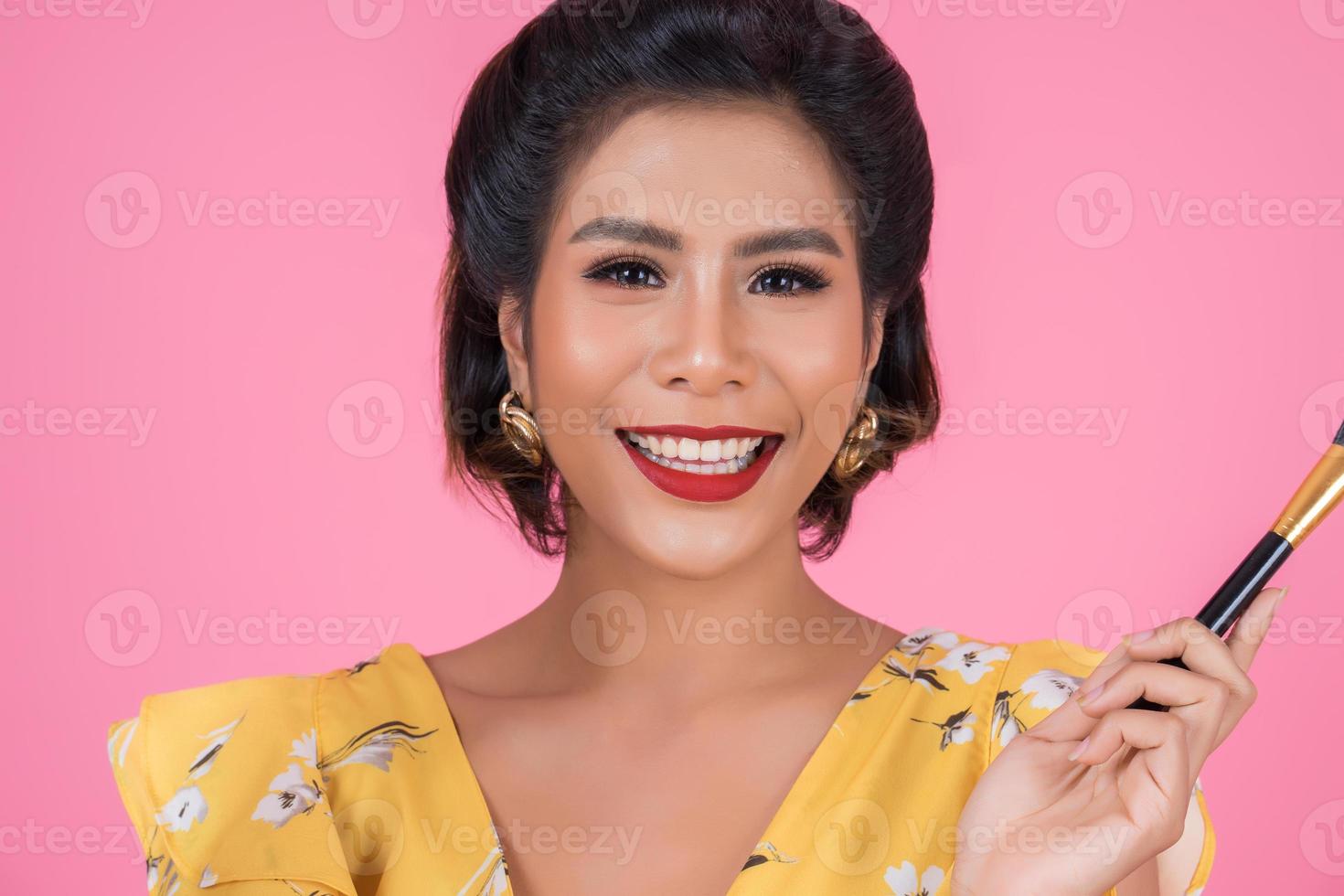 retrato de una mujer con pinceles de maquillaje foto